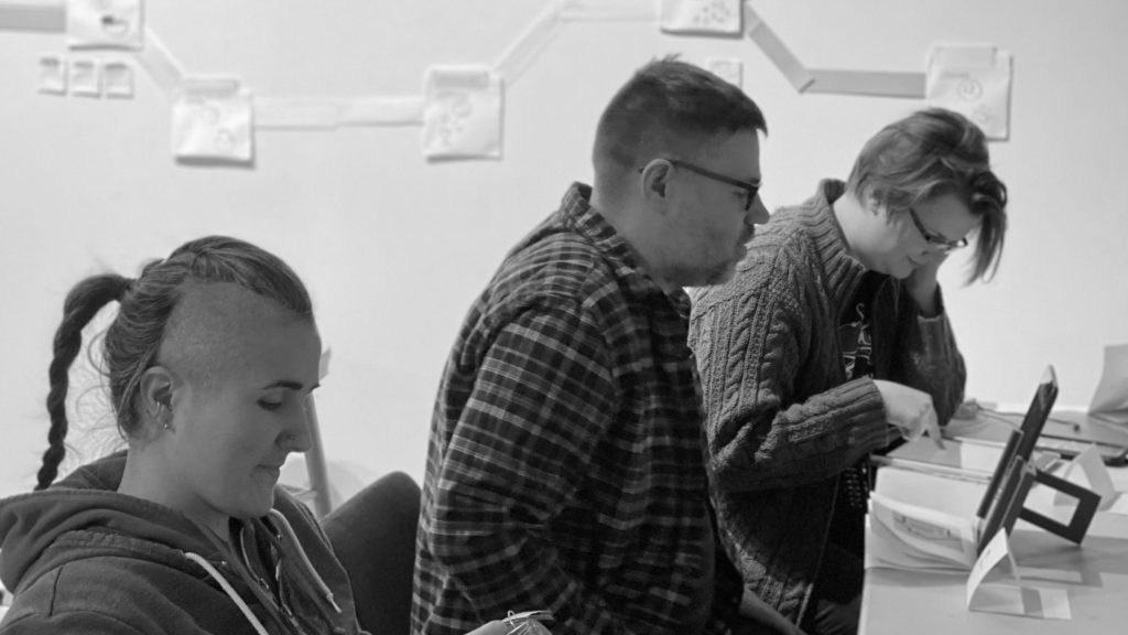 A photo showing 3 people in front of screens, and hand-made projects at one of the previous CYOA events.